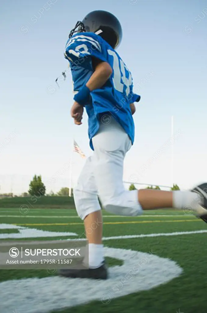 Young football player running on field