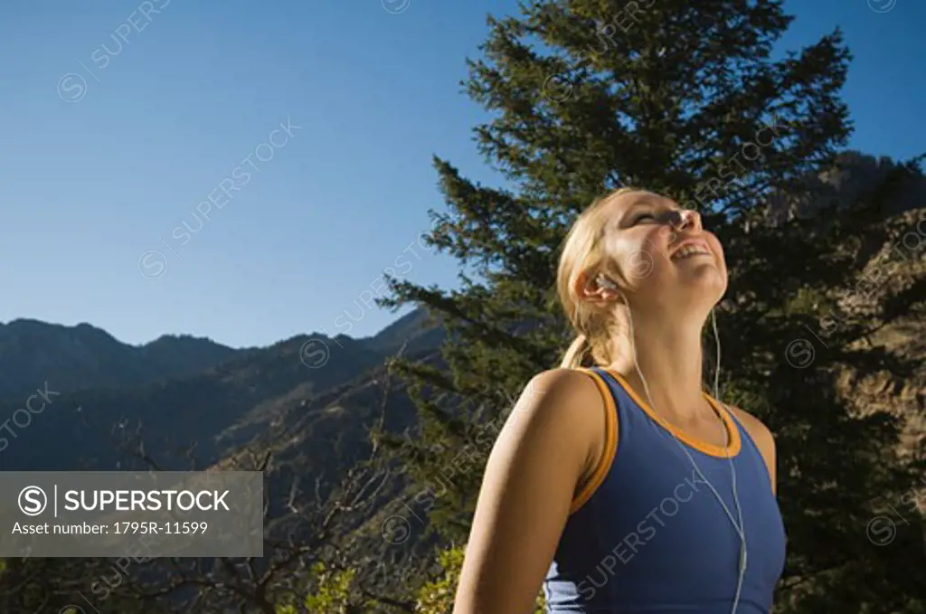 Woman listening to mp3 player, Utah, United States