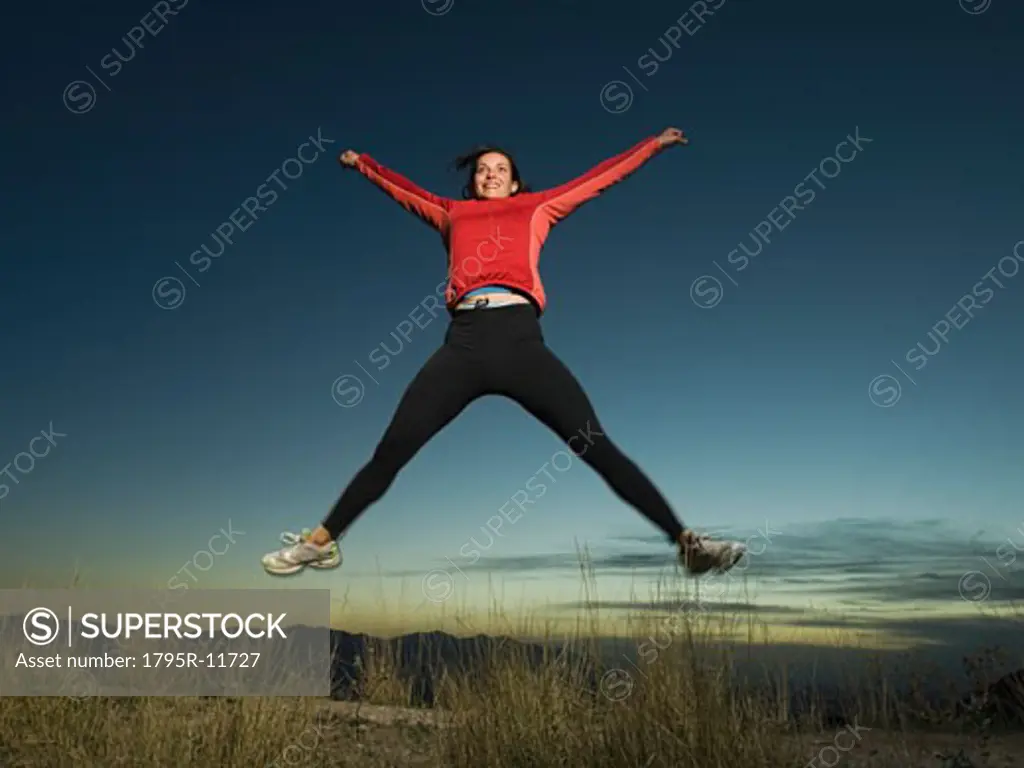 Woman jumping with arms raised, Salt Flats, Utah, United States