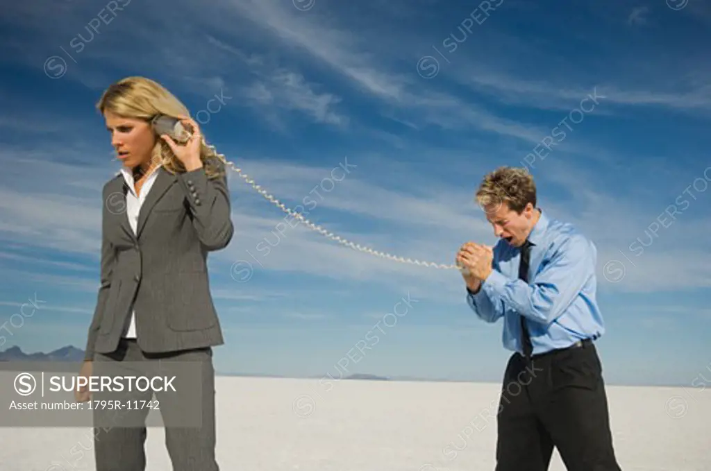 Business people talking with can and string phone, Salt Flats, Utah, United States