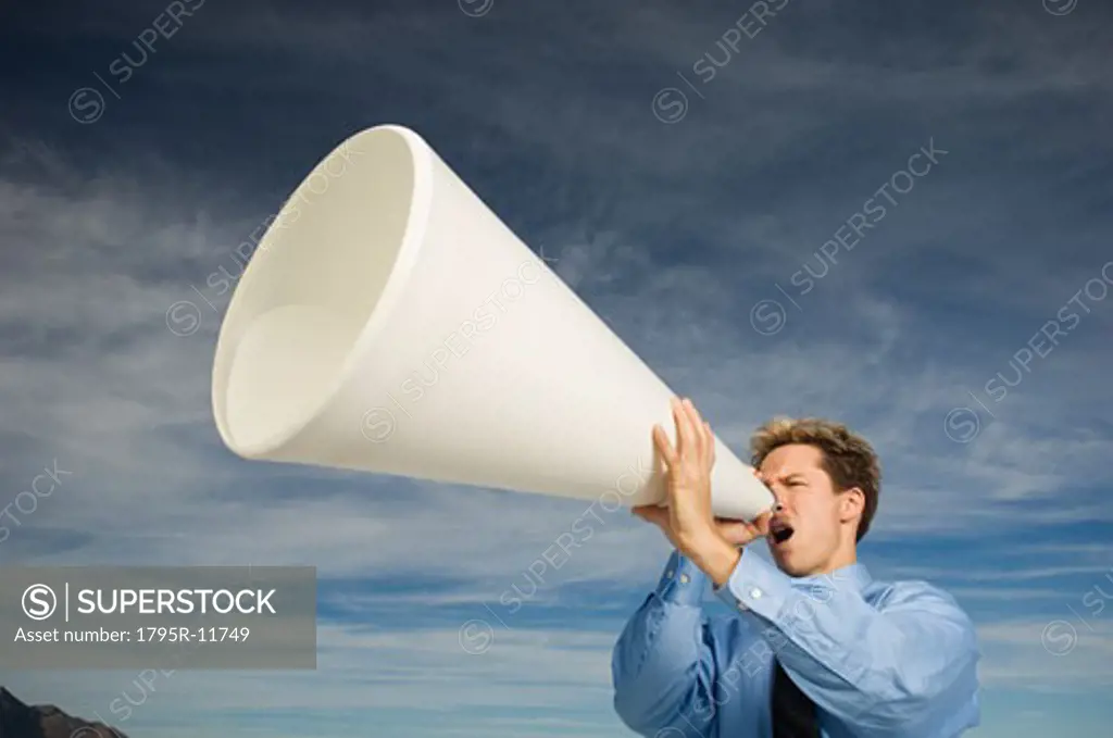 Businessman yelling into megaphone, Salt Flats, Utah, United States