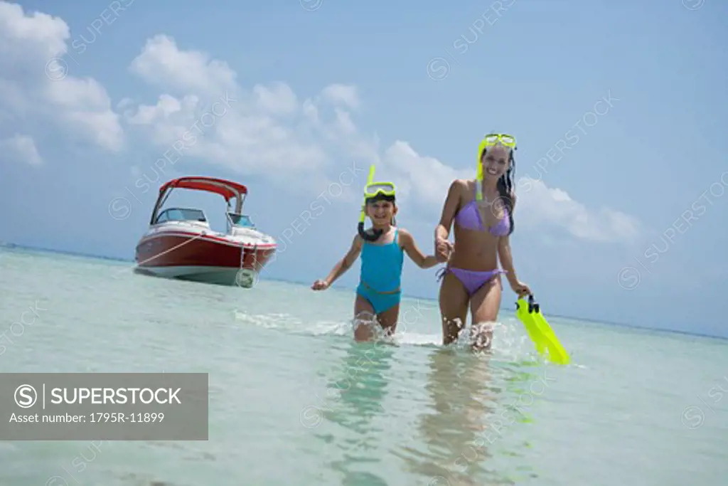 Mother and daughter with snorkeling gear walking in water, Florida, United States