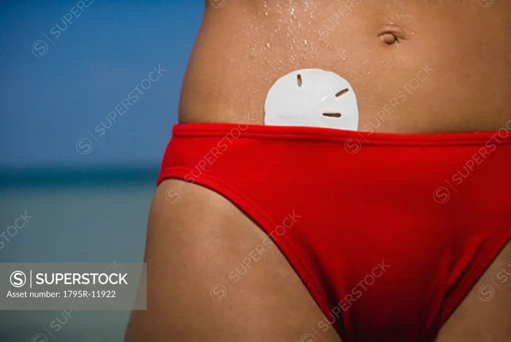 Sand dollar in womans bikini, Florida, United States