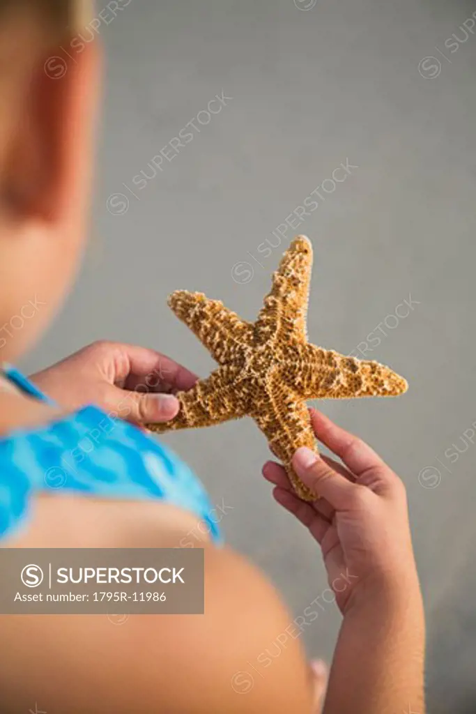 Girl holding starfish, Florida, United States