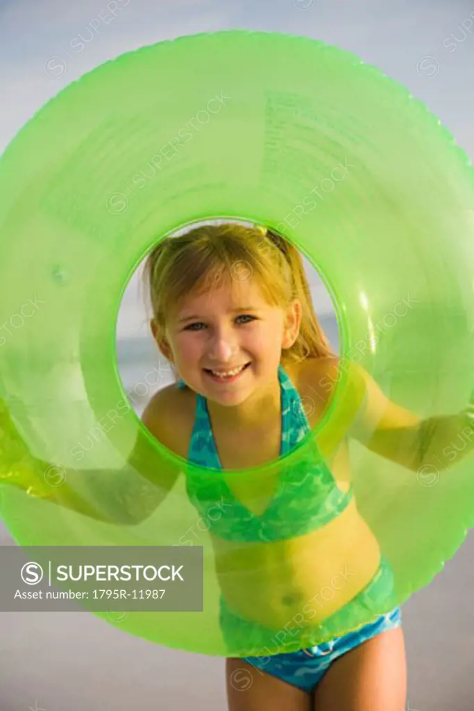 Girl looking through middle of inner tube, Florida, United States