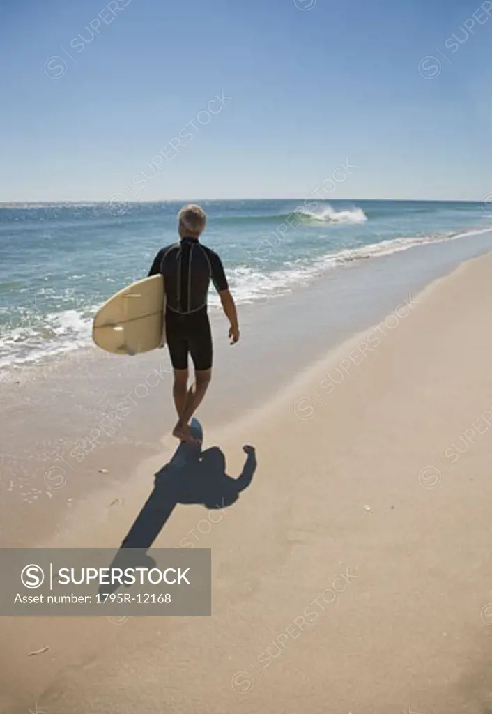 Man carrying surfboard at beach