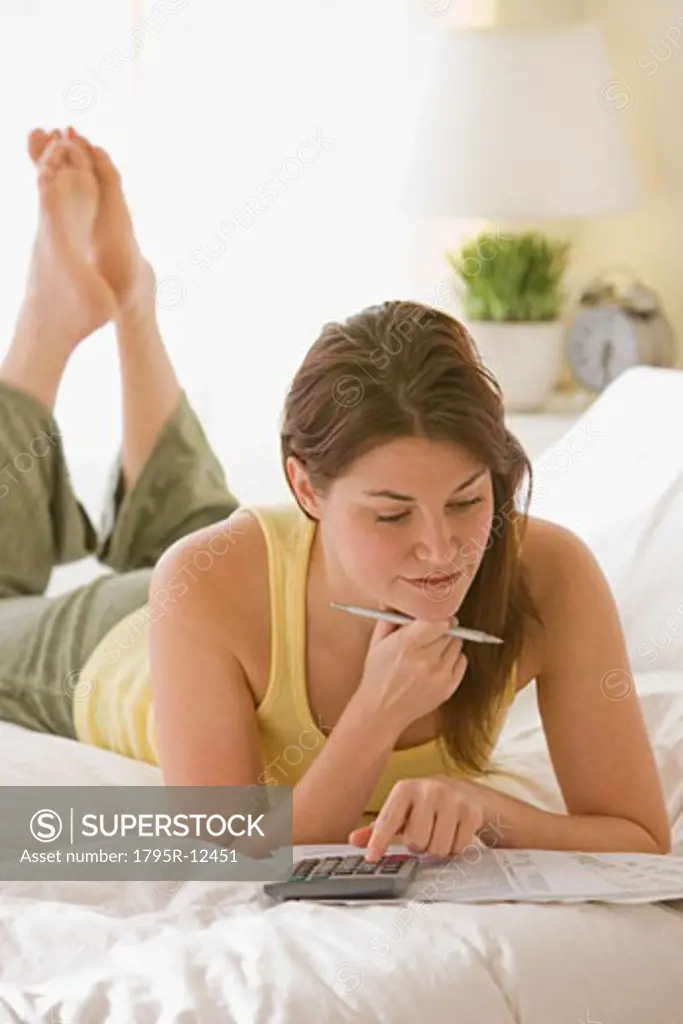 Woman doing finances on bed