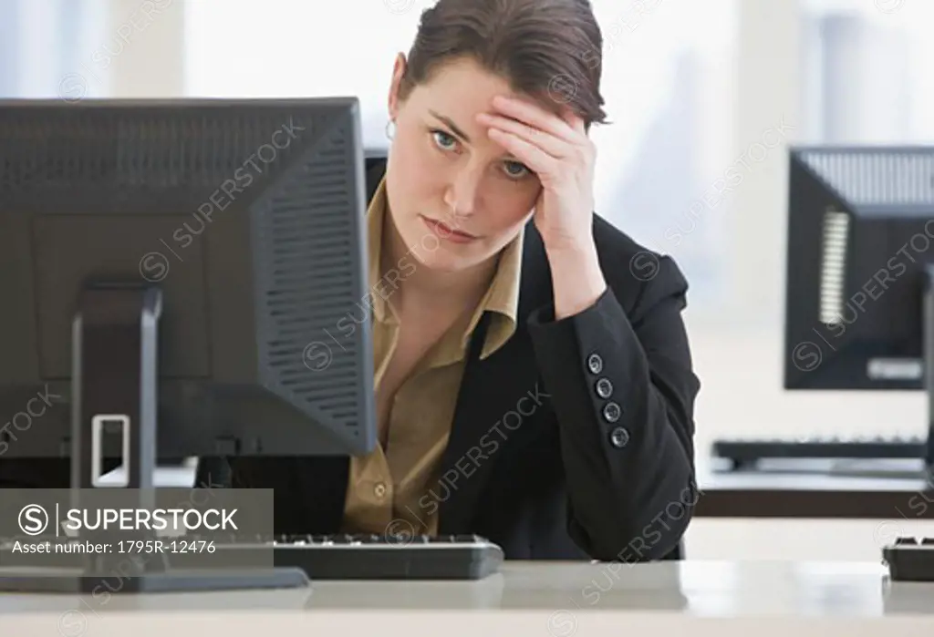 Frustrated businesswoman leaning on desk