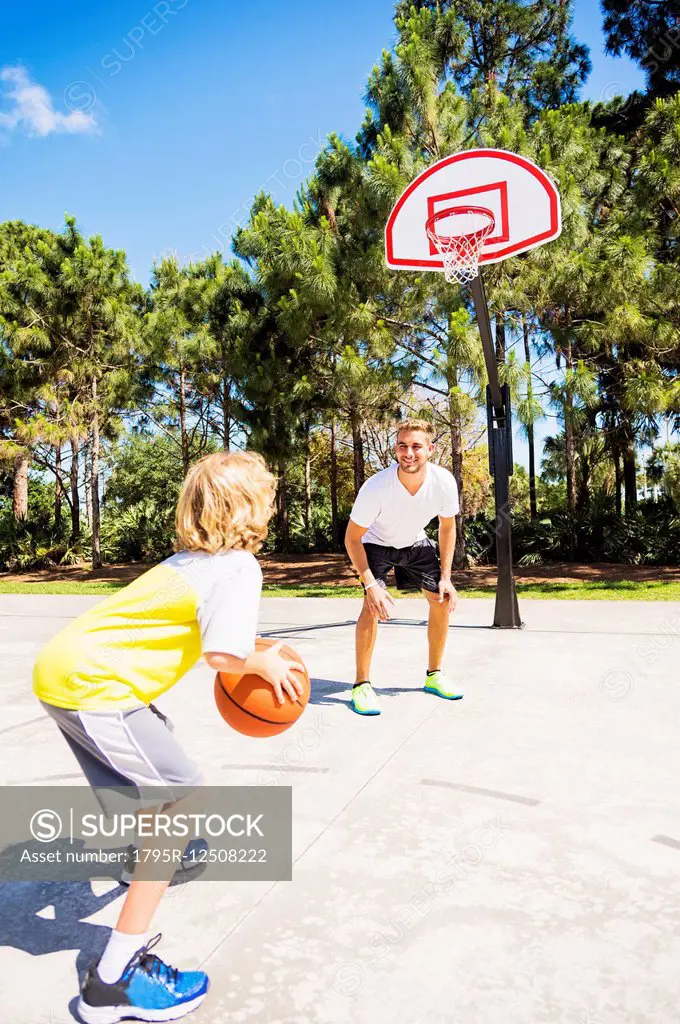 Boy (8-9) playing basketball with his brother