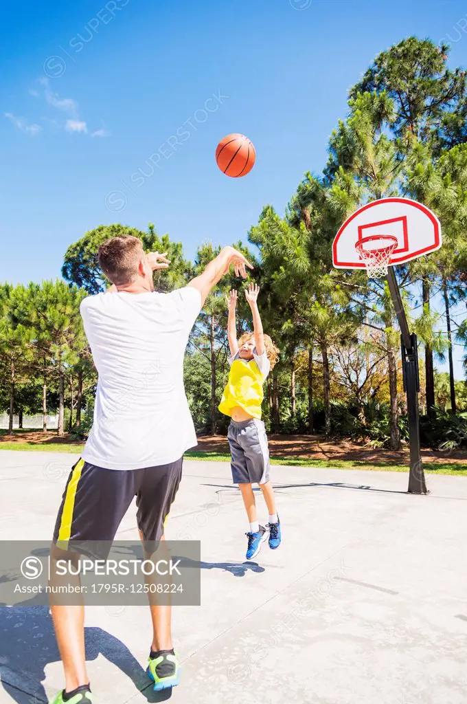 Boy (8-9) playing basketball with his brother