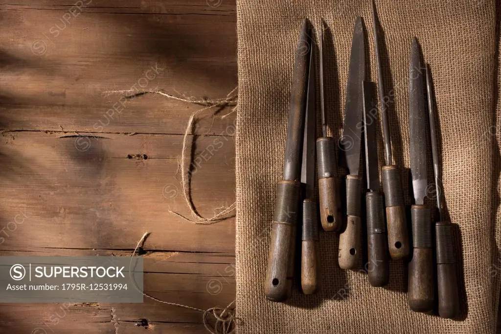 Silversmith's tools arranged on workbench, wood and linen fabric