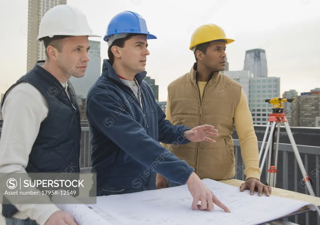 Multi-ethnic construction workers with blueprints