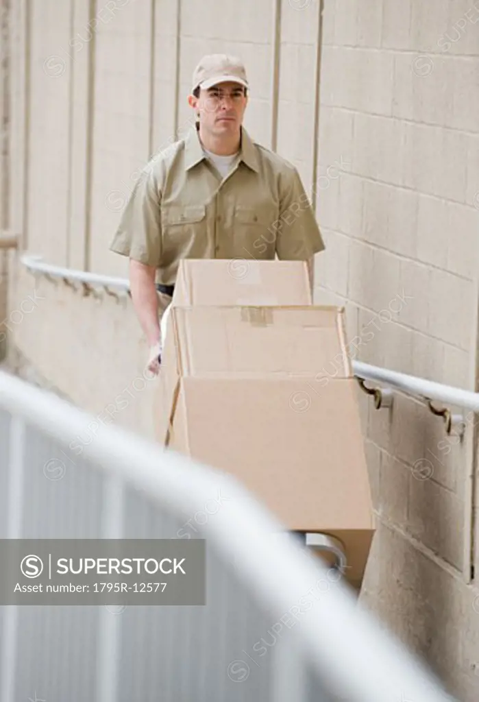 Delivery man pushing stack of packages