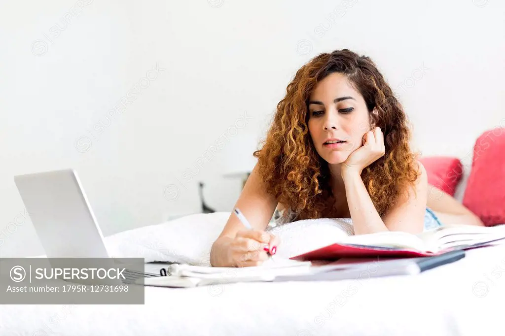 Woman with laptop in bed