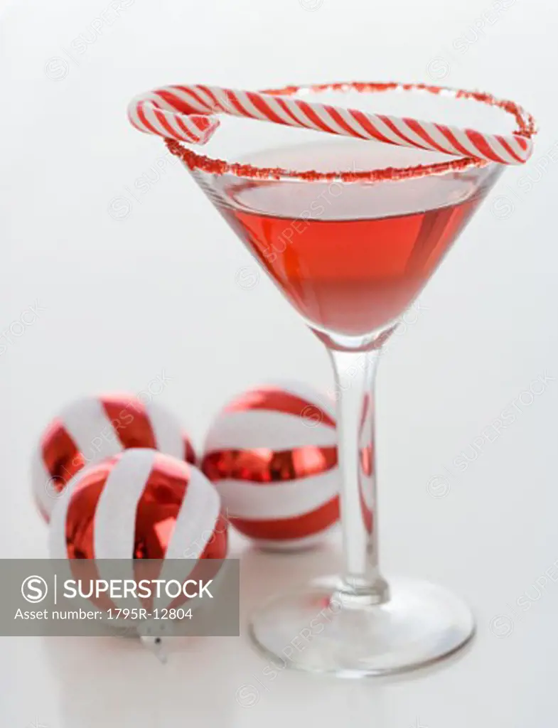 Cocktail with candy cane and Christmas ornaments