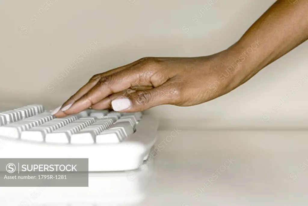 A woman's hand on computer keyboard