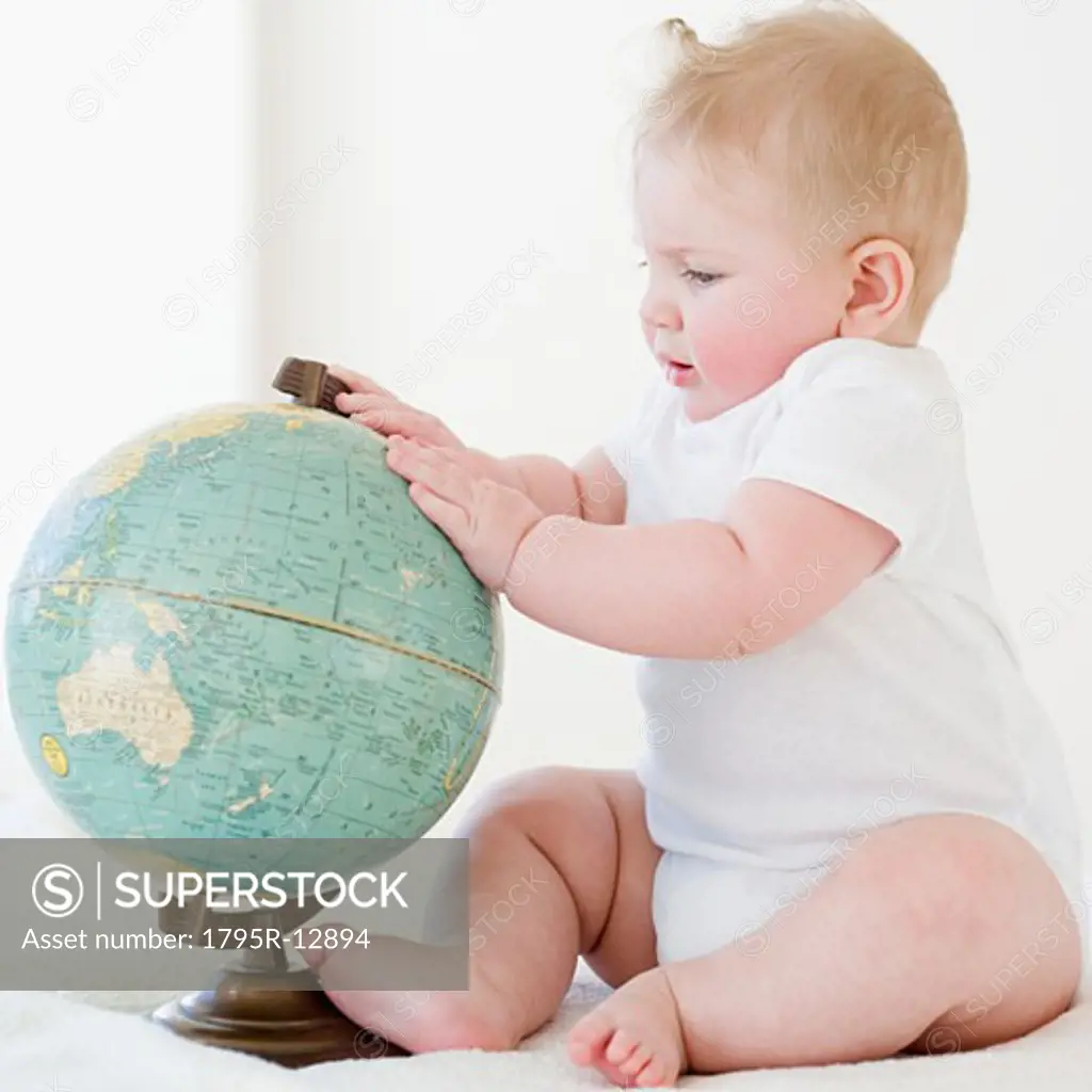 Baby looking at globe