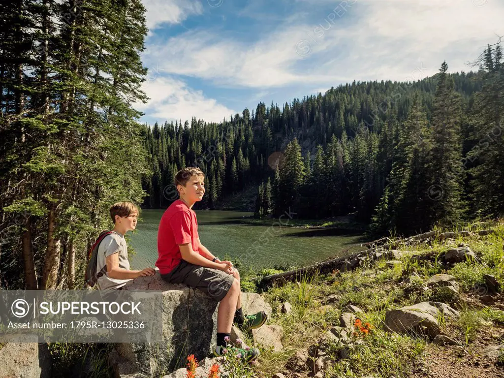 Two boys (10-11, 12-13) resting in forest