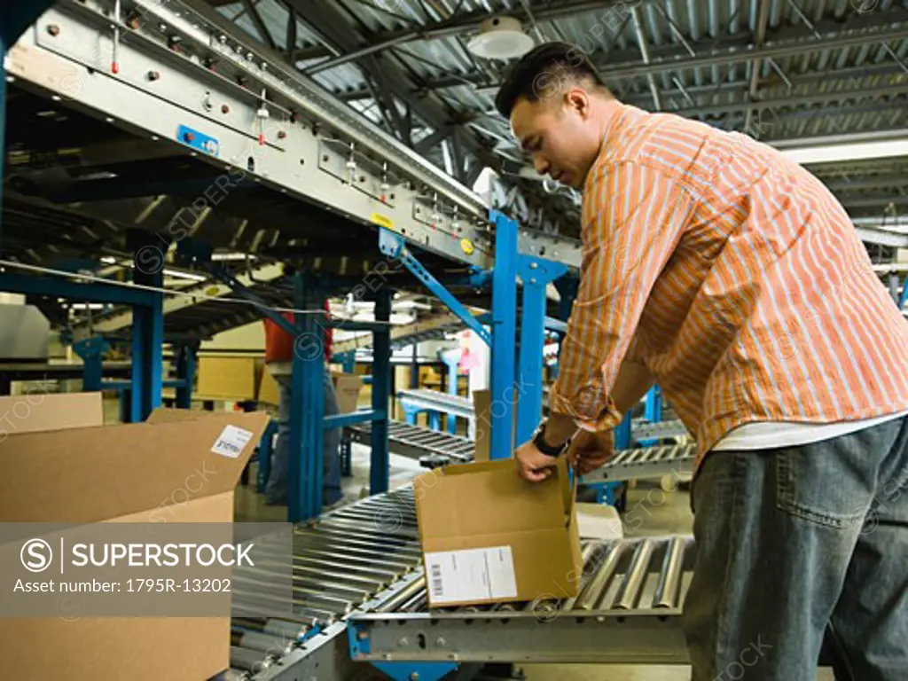 Asian male factory worker checking product