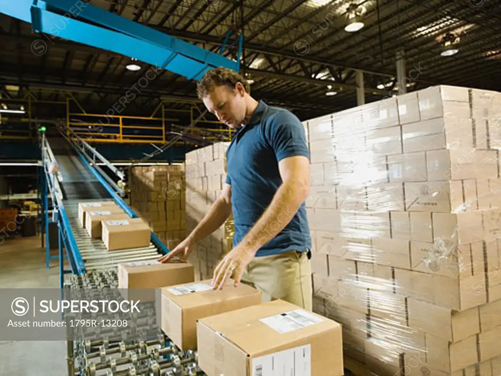 Warehouse worker checking packages on conveyor belt