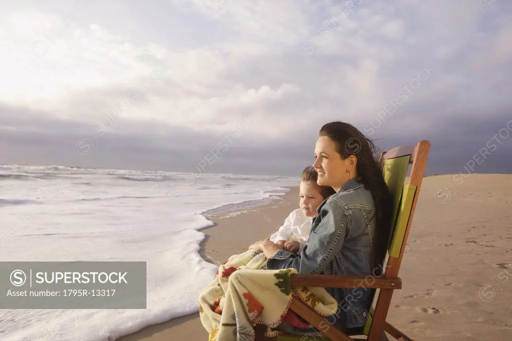 Mother and child sitting in beach chair