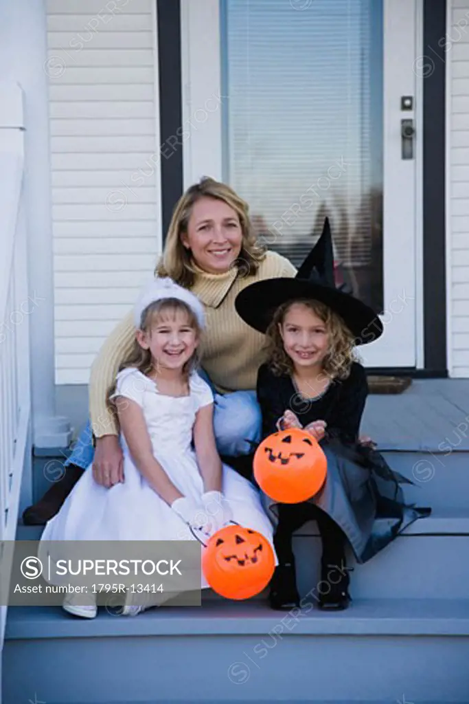 Mother and daughters dressed in witch and princess Halloween costumes