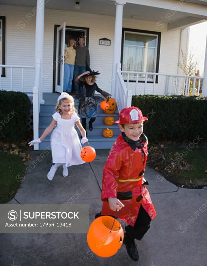 Children dressed in Halloween costumes leaving house