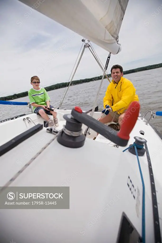 Father and son sitting on sailboat