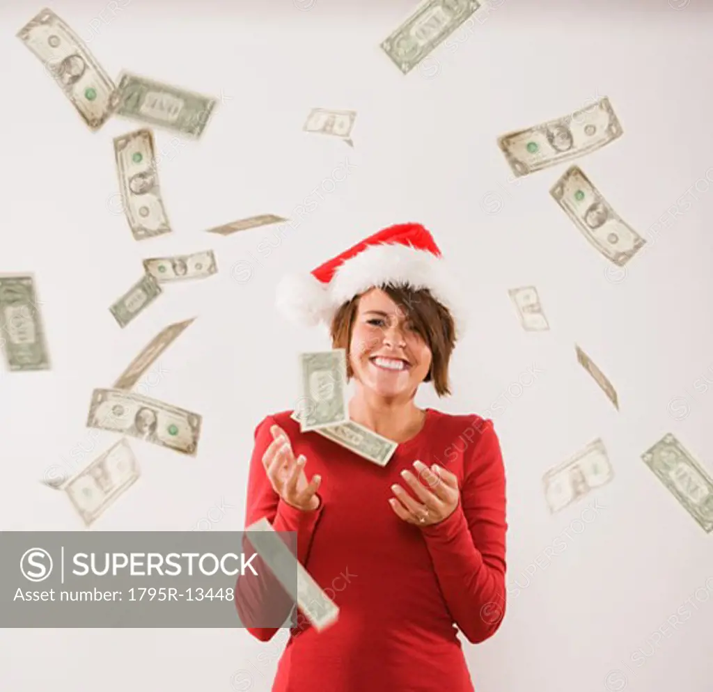Money raining down on woman in Santa Claus hat