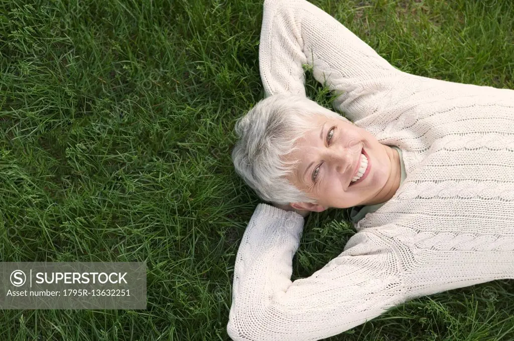 Smiling mature woman lying on grass