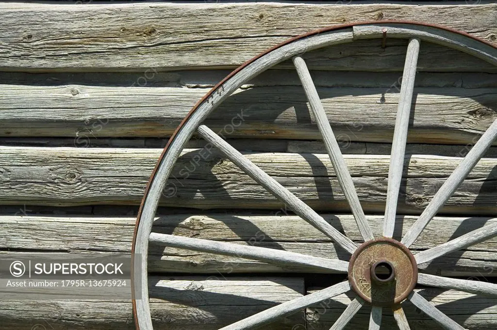 Wagon wheel against wooden wall