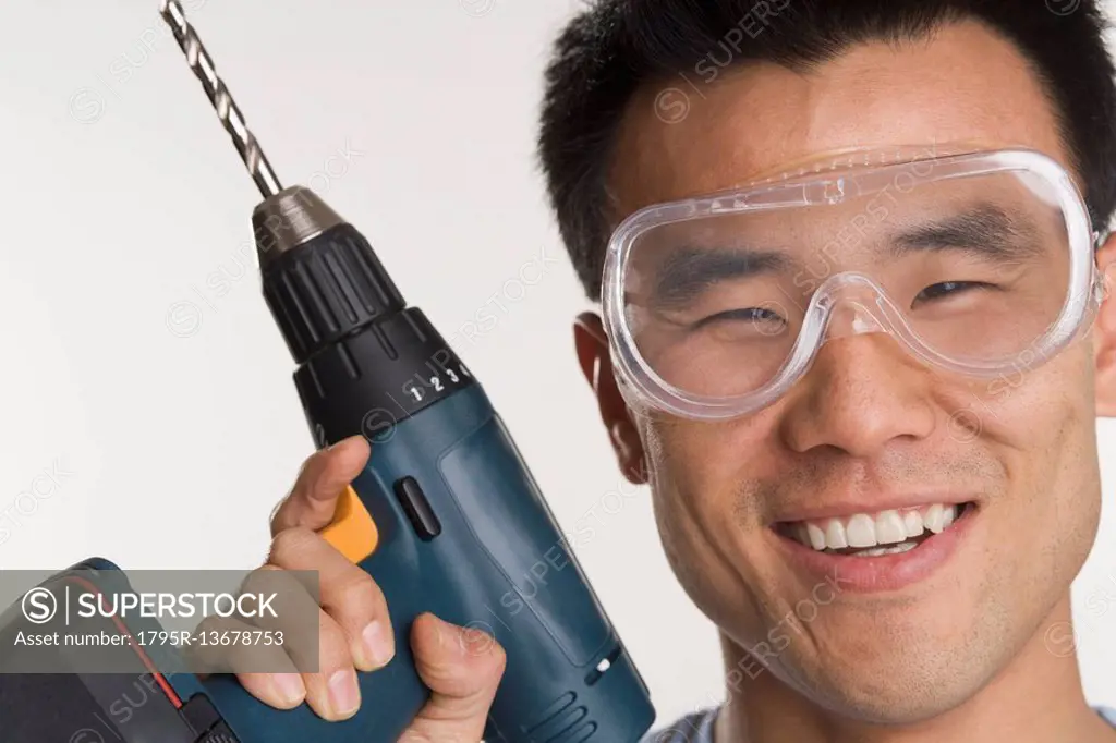 Portrait of man with electric drill