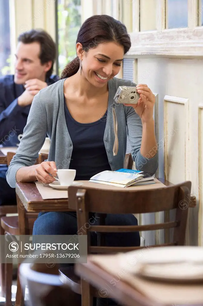 Woman looking at digital camera in restaurant