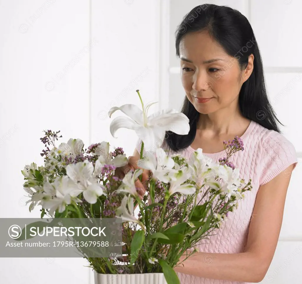 Woman arranging bouquet of flowers
