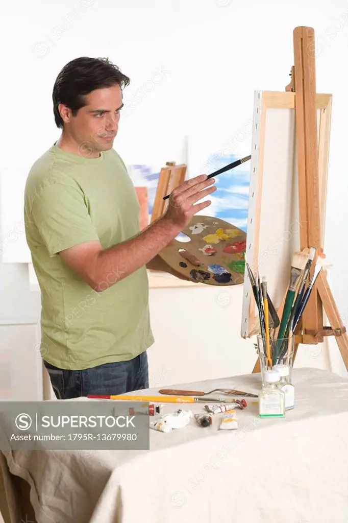 Man painting at easel indoors