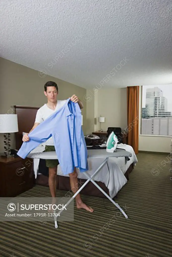 Businessman ironing shirt