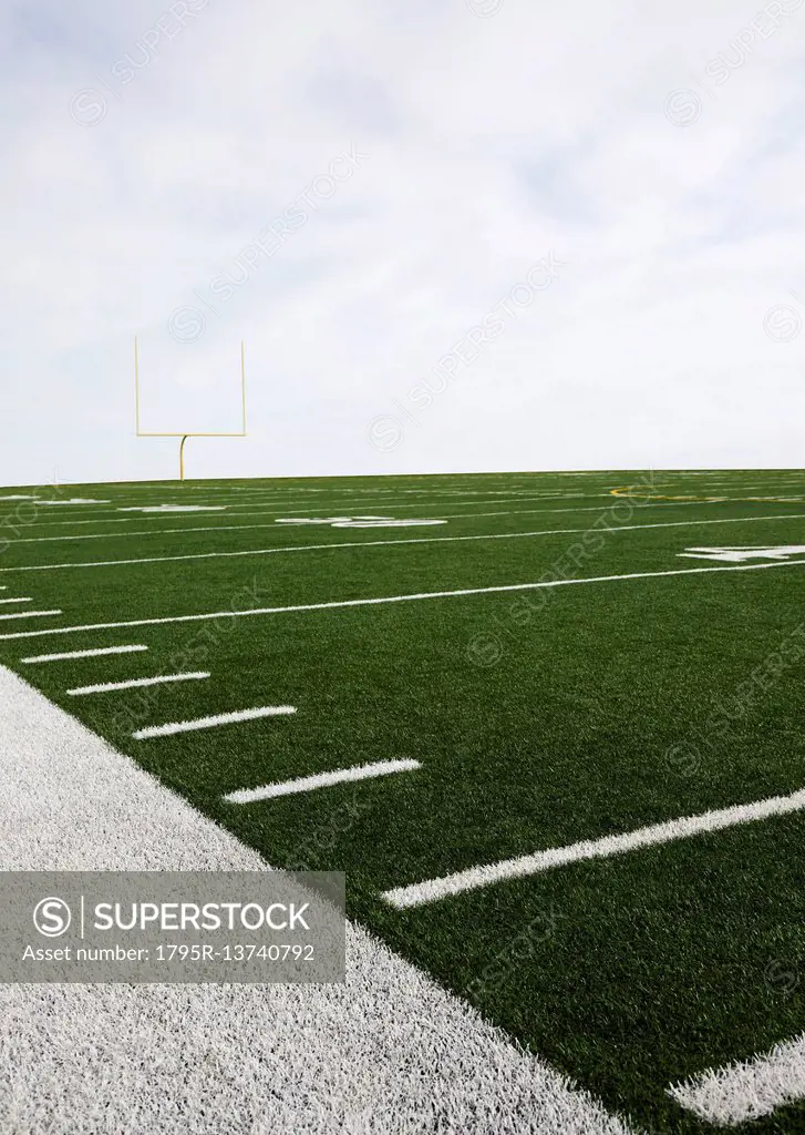 Overcast sky above american football field and goal post - SuperStock