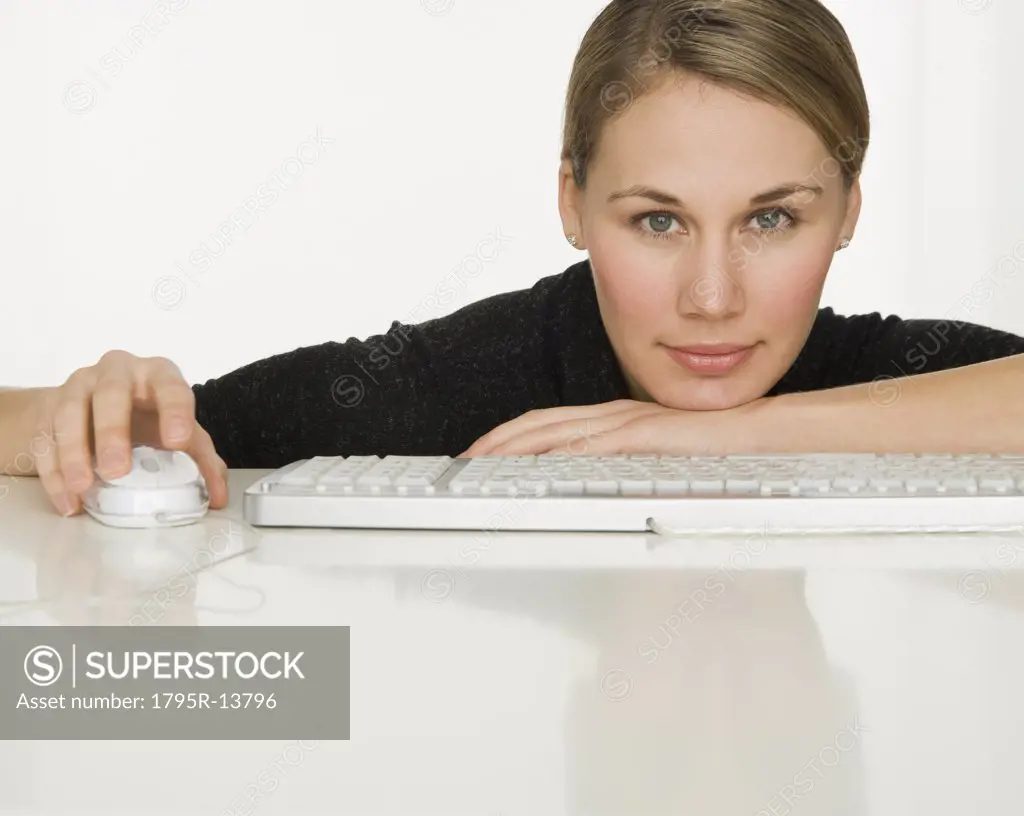 Woman leaning on table next to keyboard