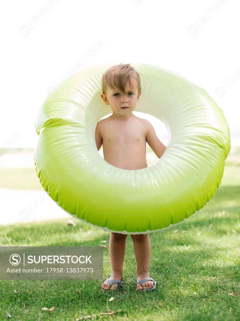 Boy (2-3) standing with inflatable ring