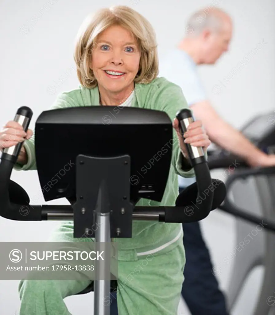 Senior woman riding on exercise machine