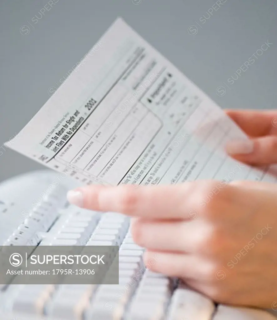 Woman holding tax form over keyboard