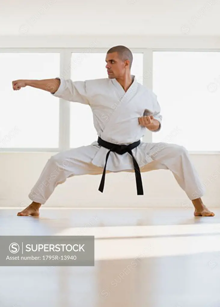 Hispanic male karate black belt in fighting stance
