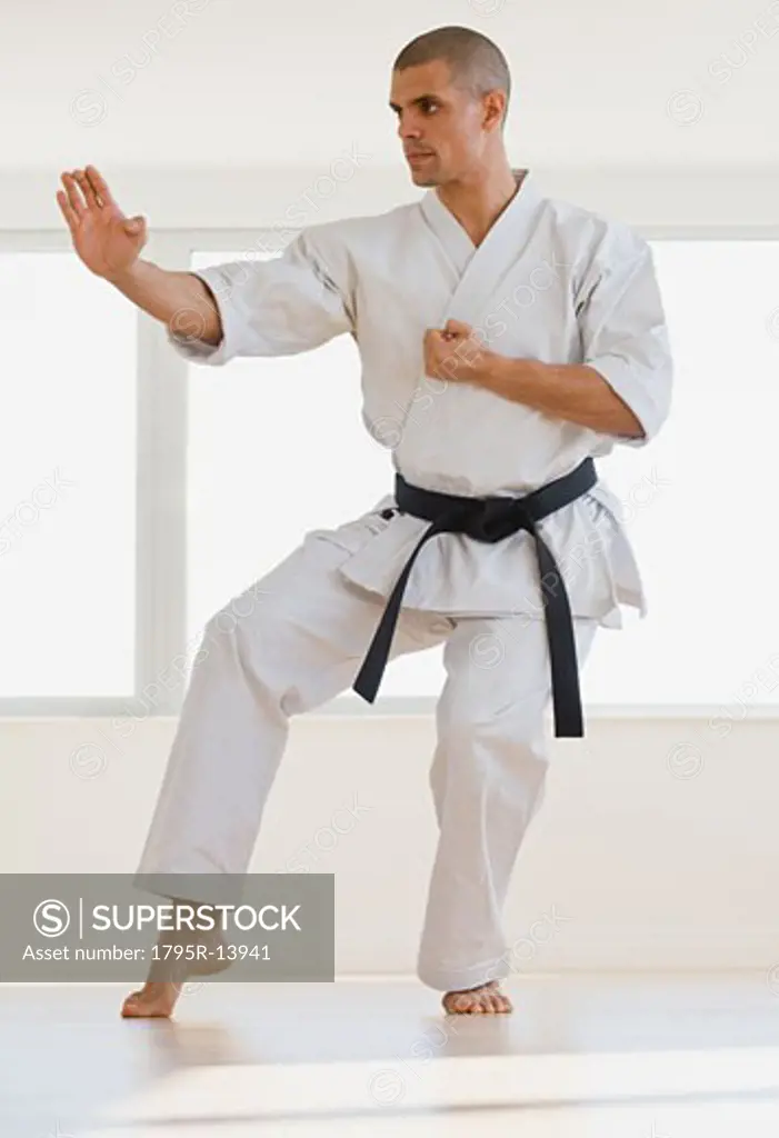 Hispanic male karate black belt in fighting stance