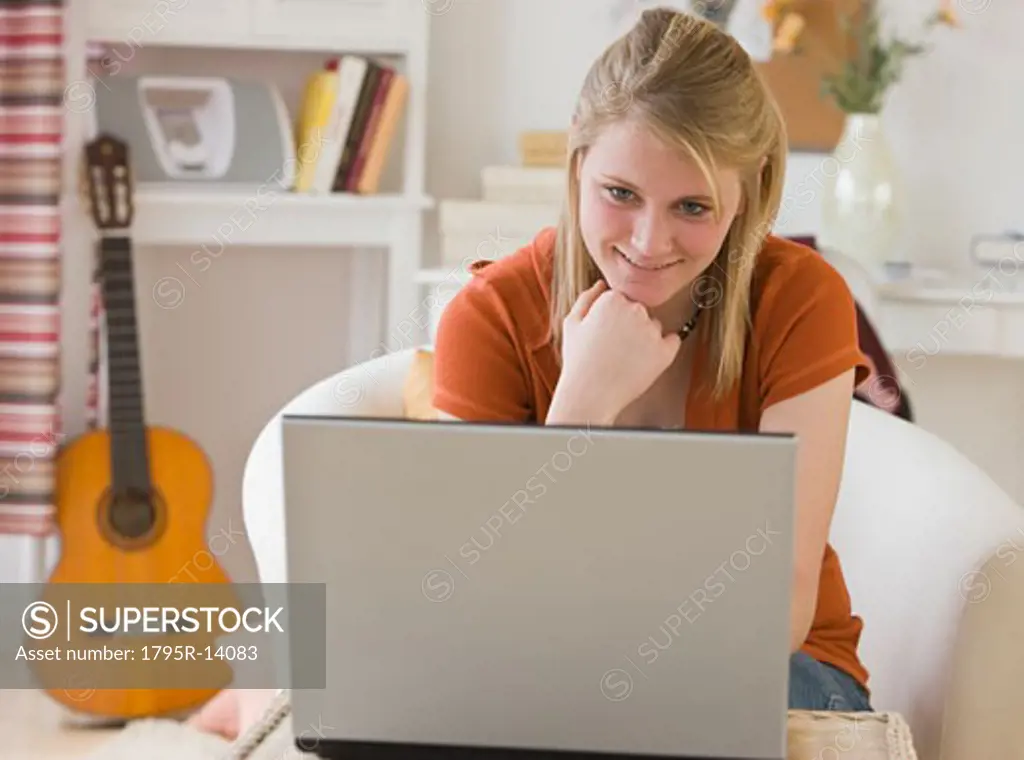 Teenaged girl looking at laptop