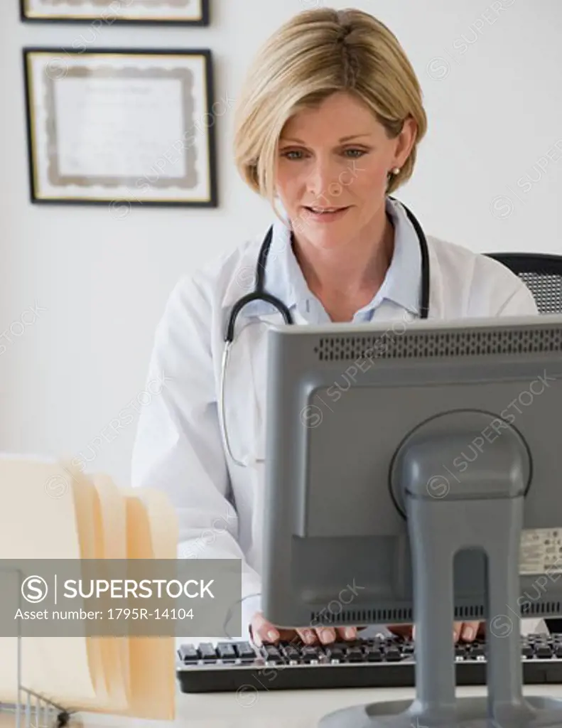 Female doctor typing on computer