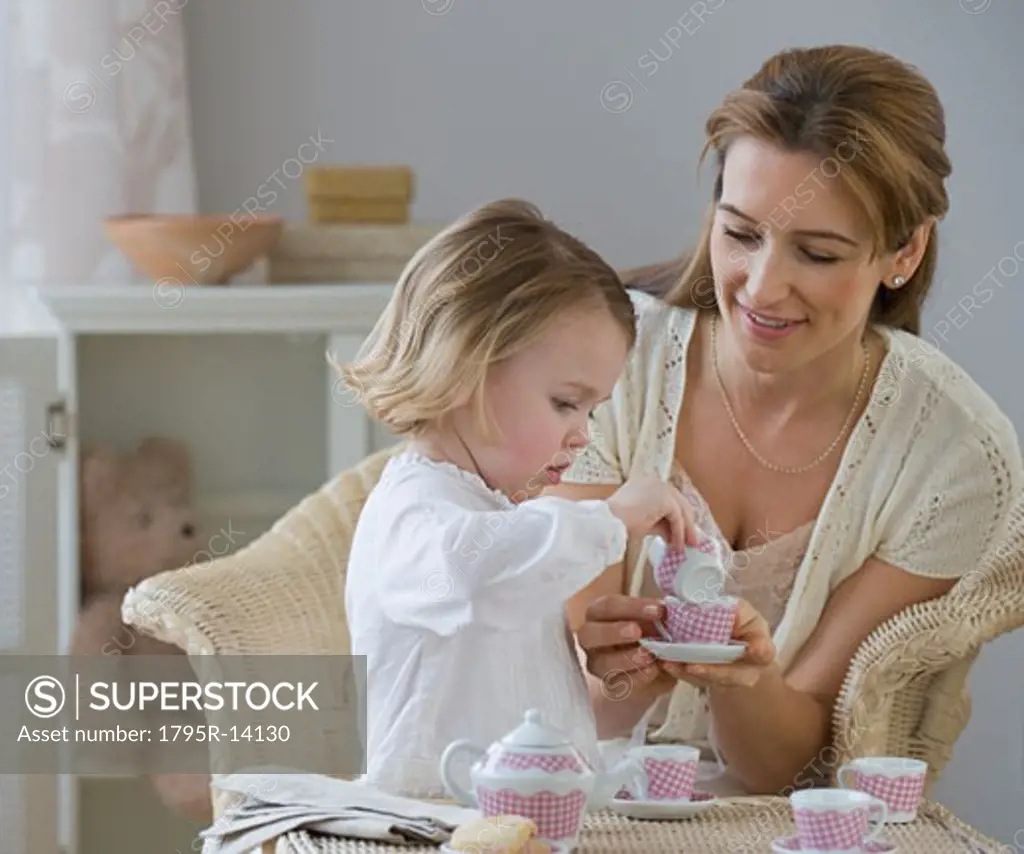 Mother and daughter playing with tea set