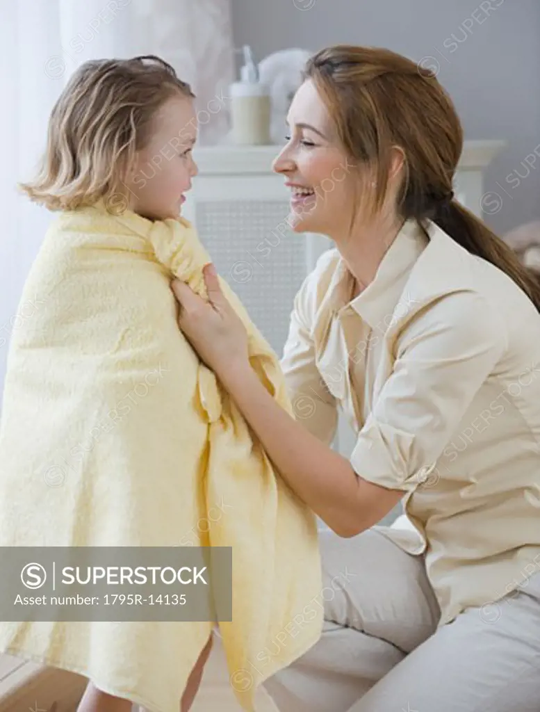 Mother drying daughter with towel