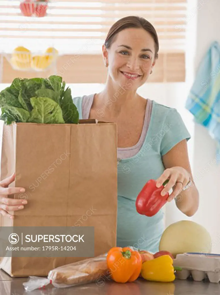 Pregnant Hispanic woman unpacking groceries