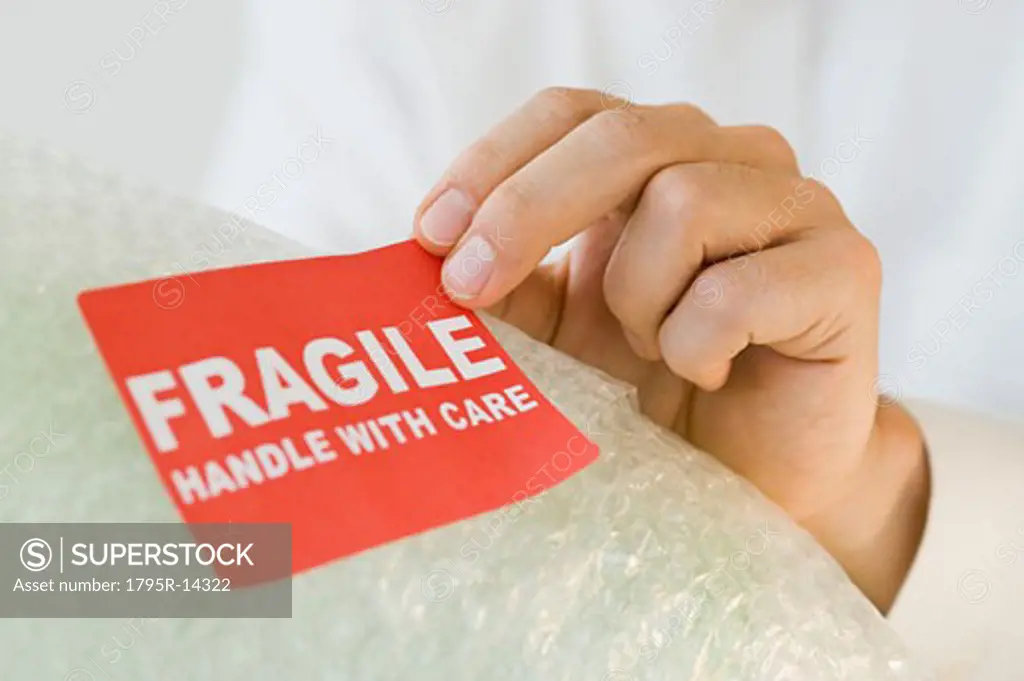 Man affixing fragile sticker