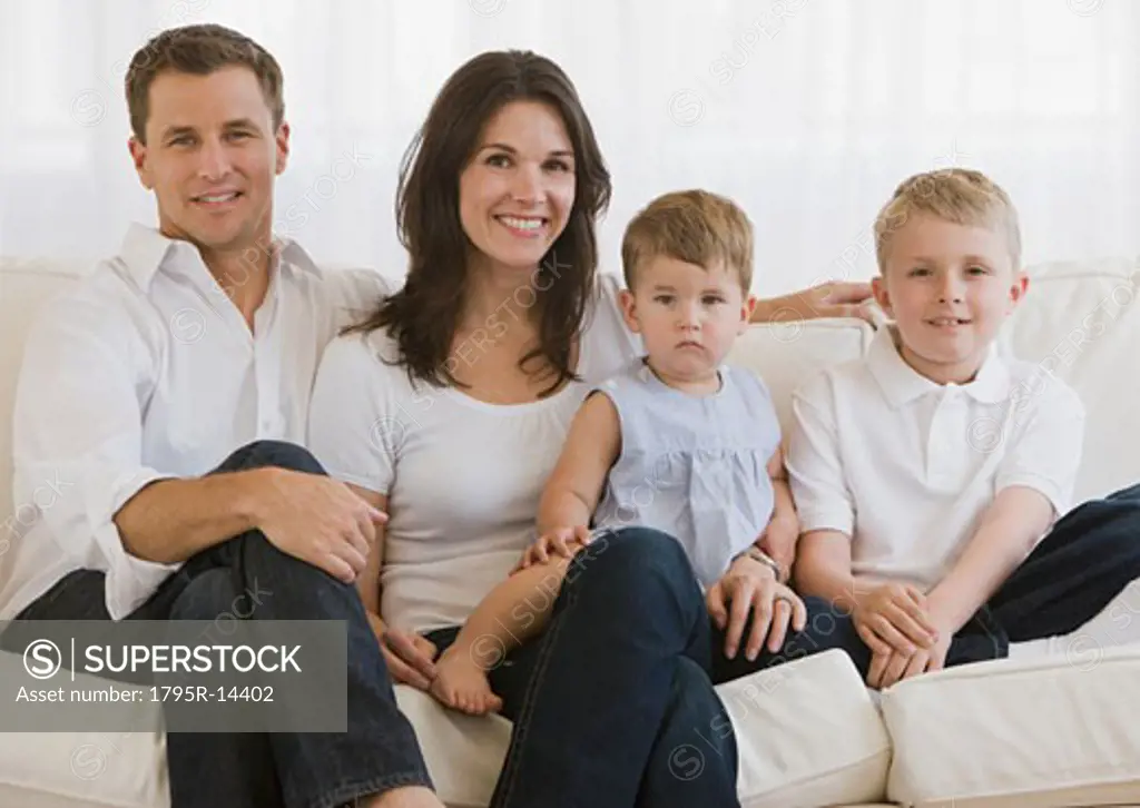 Family with two children sitting on sofa
